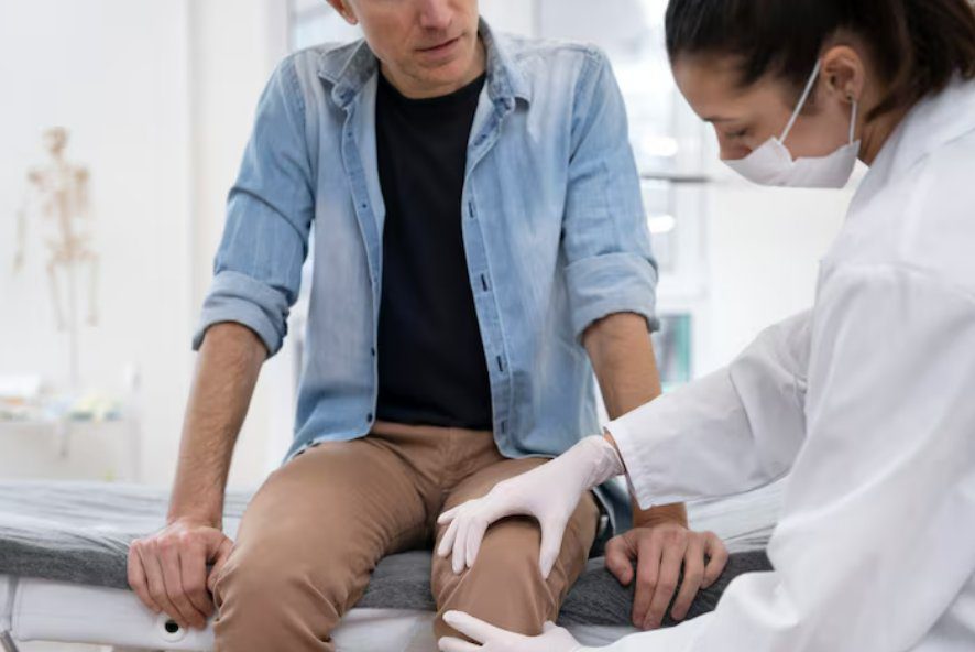 Specialist examining a patient's knee during a cartilage injury assessment in Singapore