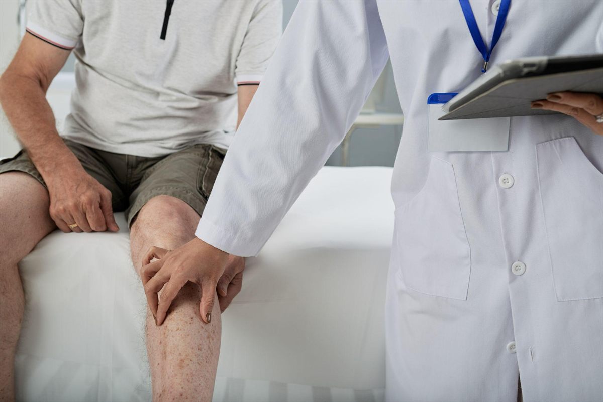 Doctor examining a patient's knee to assess a suspected meniscus injury