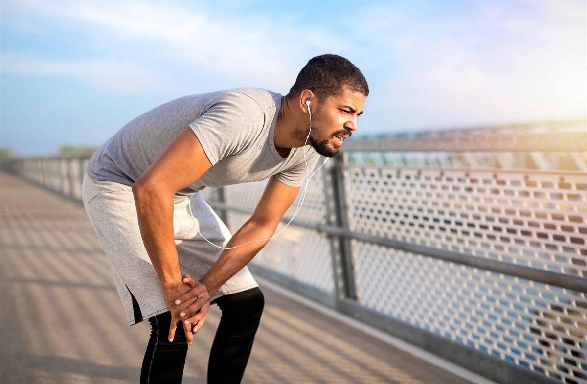 Runner holding his knee in pain, a common sign of meniscus tear symptoms