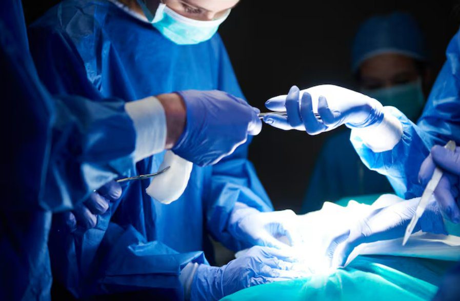 Surgical team performing a total knee replacement procedure in an operating theatre
