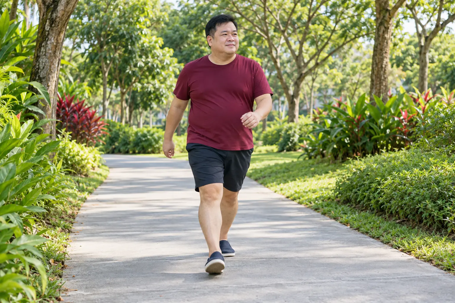 A man of heavier build walks briskly along a park path.
