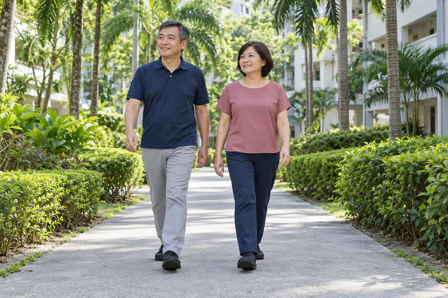 A Chinese man walks with his wife along a quiet estate path.