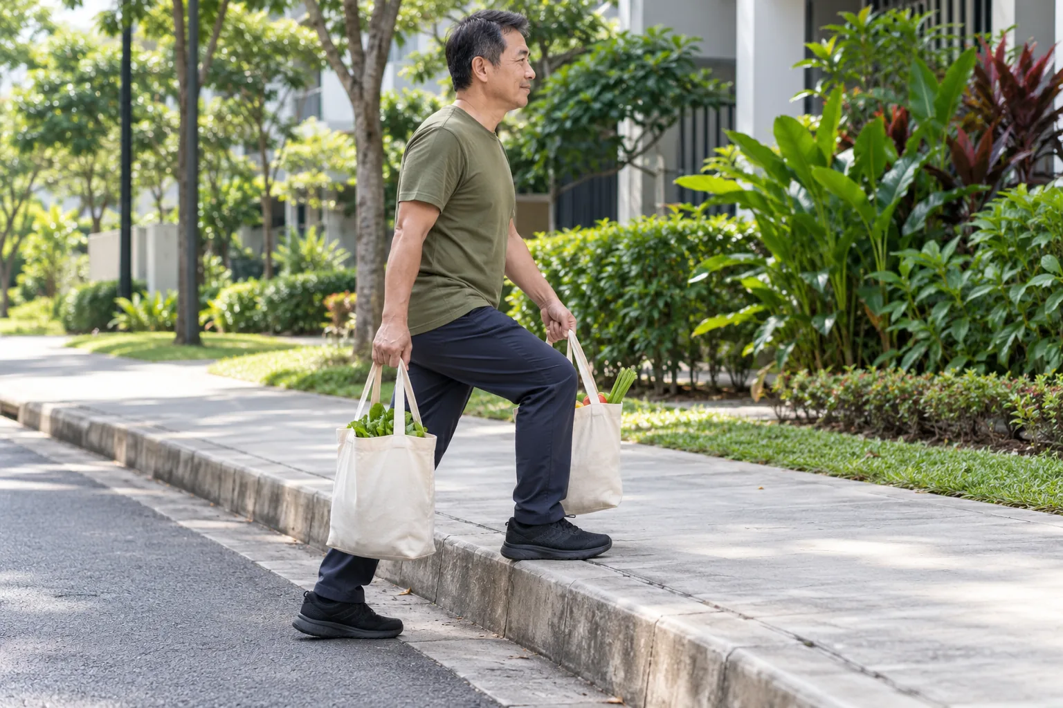 A man steps up a kerb carrying two cloth grocery bags with his leading knee bent.