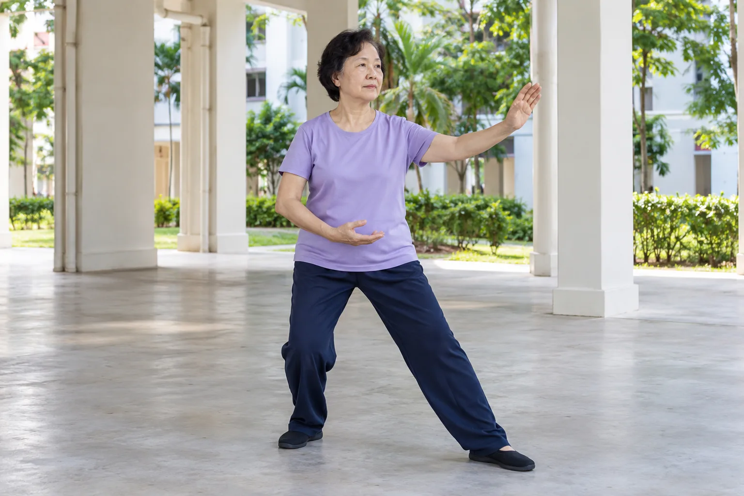 A Chinese woman practises tai chi in an HDB void deck in the morning.